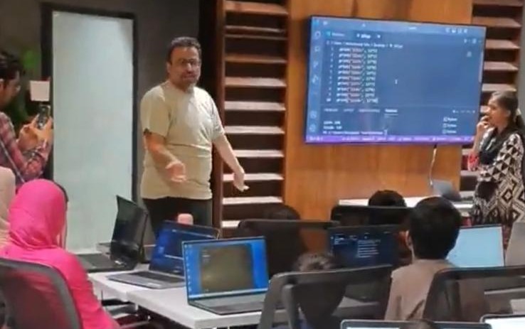 Professor writing mathematical formulas on a blackboard